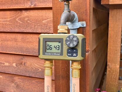 Garden In Minutes two zone timer attached to an outdoor spigot with two hoses connected